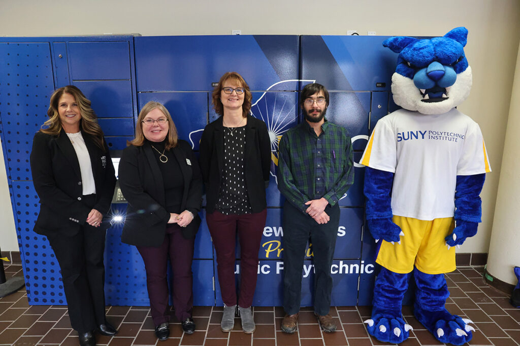 Walter the Wildcat and staff showcasing the new Poly Pantry Food Lockers.