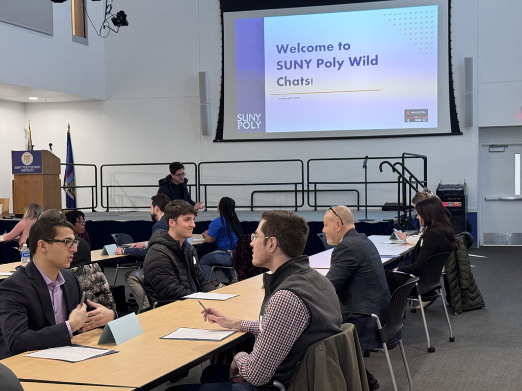 Students seated across from professionals during structured networking conversations.