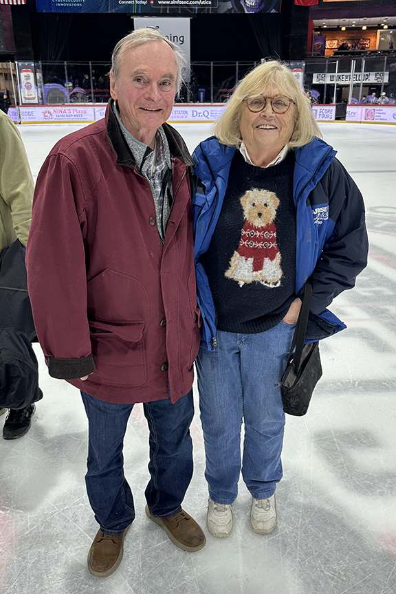 Two alumni at center ice at the Utica Comets Hockey game.