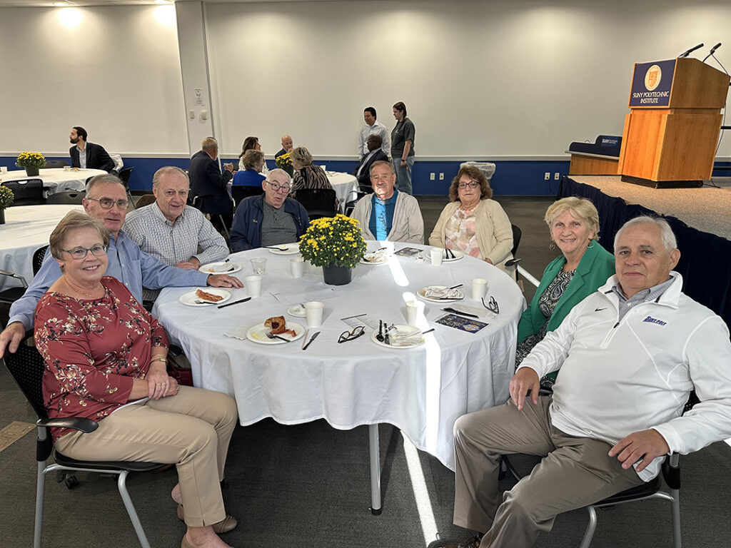 Group of alumni sitting at a round table.