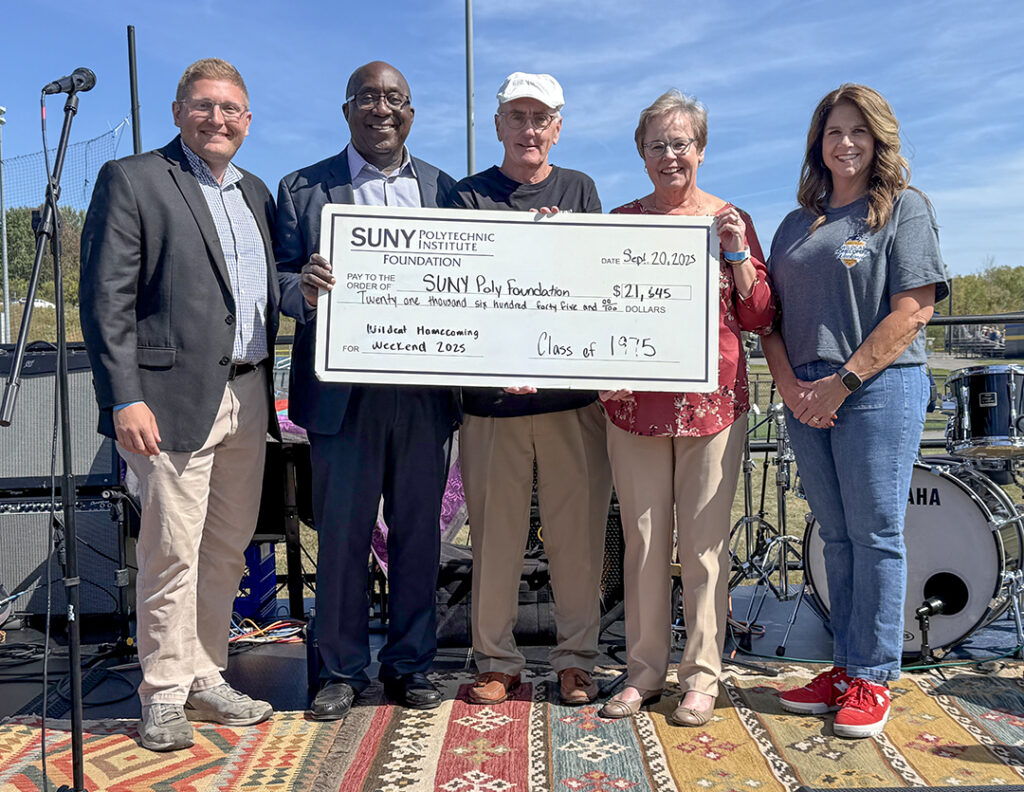 Alumni staff photographed with a check to the Alumni Foundation for Wildcat Homecoming Weekend.
