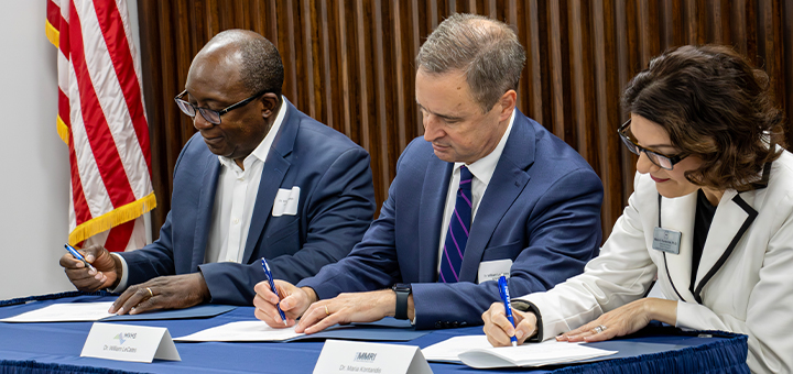 SUNY Poly President and MVCC staff at a table signing.