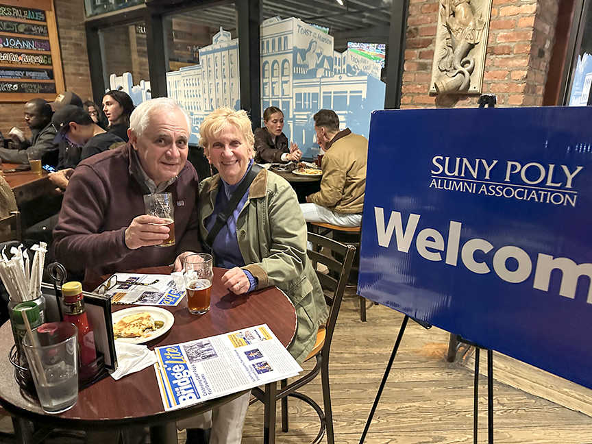 Two alumni photographed in Brown's Brewing Company.