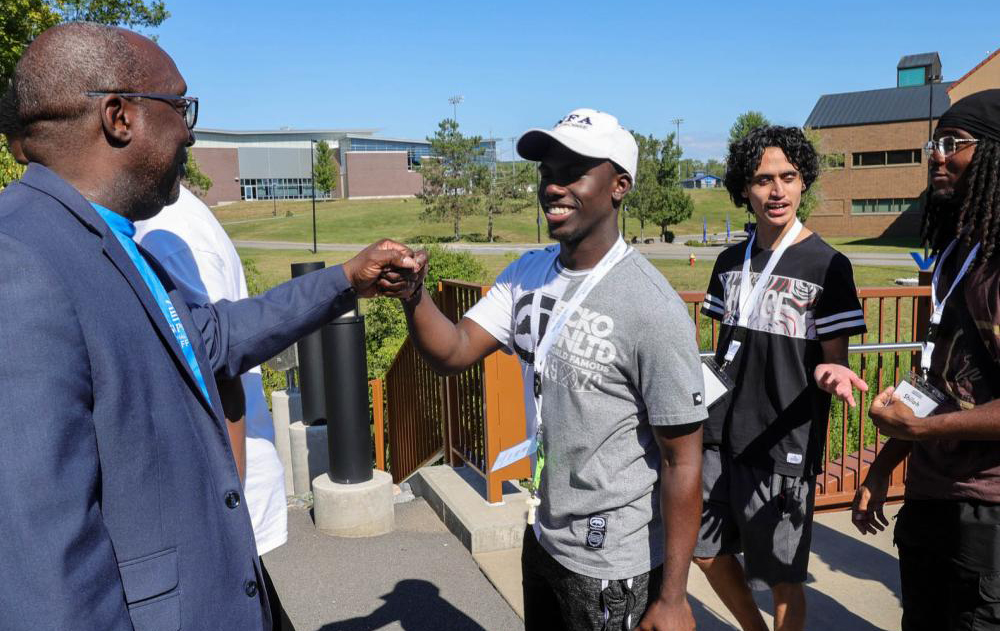 President Soboyejo fist bumping a first year student.